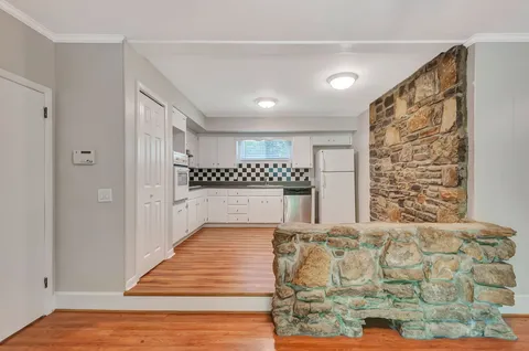 a view of a bedroom with wooden floor & a ceiling fan