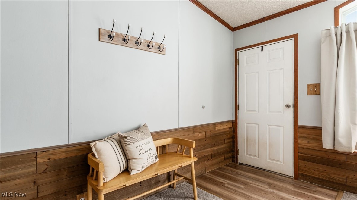 13306 Fairview Road Southeast Newark, OH 43056 - Photo 7 of 48 Sitting room featuring crown molding, wood finished floors, a textured ceiling, wainscoting, and wooden walls