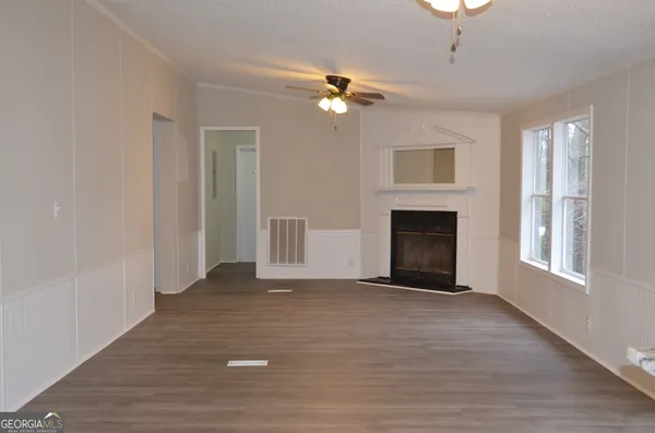 a view of empty room with fireplace and wooden floor