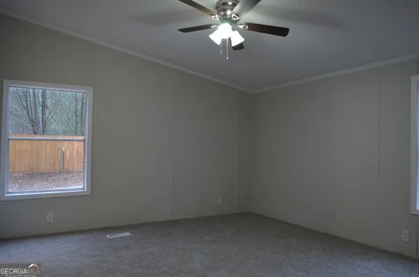 an empty room with a window and a fan