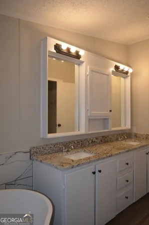 a bathroom with a granite countertop sink and a mirror