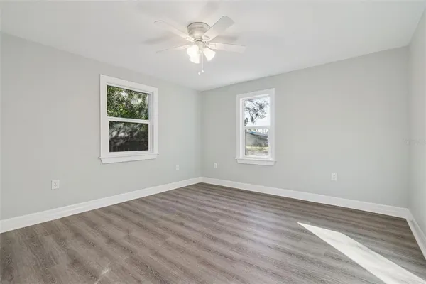 a view of an empty room with a window and a ceiling fan