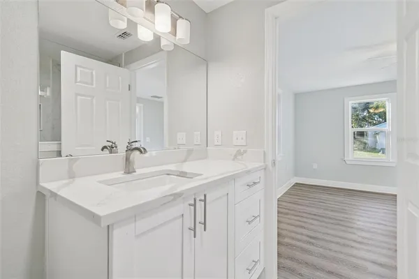 a bathroom with a sink a mirror and a vanity