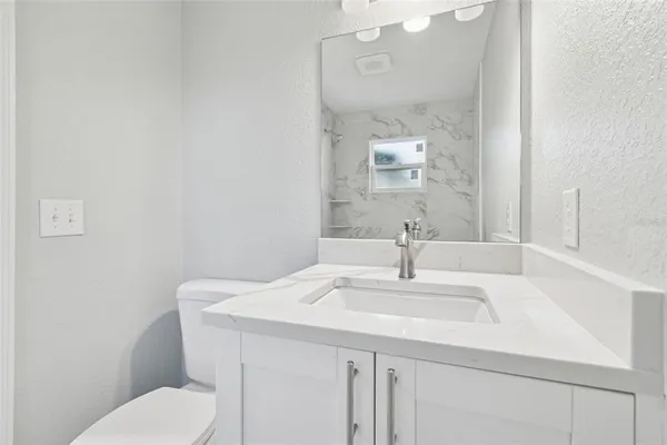 a bathroom with a sink a toilet and mirror