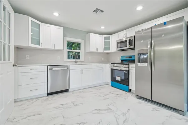 a kitchen with white cabinets and white stainless steel appliances