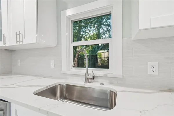 a view with granite countertop a sink and a window