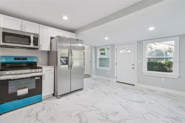 a view of a kitchen with a stove fridge and wooden floor