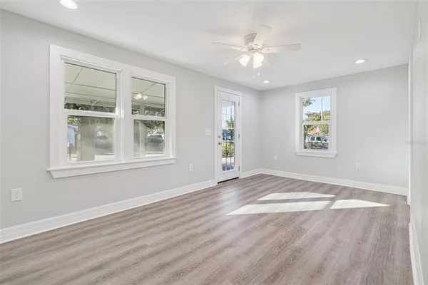 a view of an empty room with a window and wooden floor
