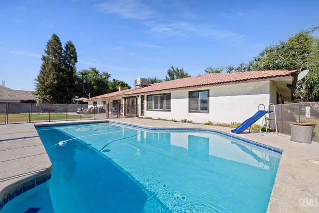 a view of a patio with table and chairs with wooden floor and fence