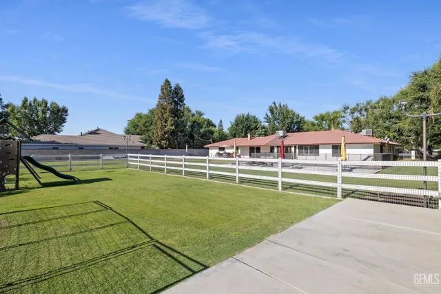 an aerial view of residential houses with outdoor space and trees