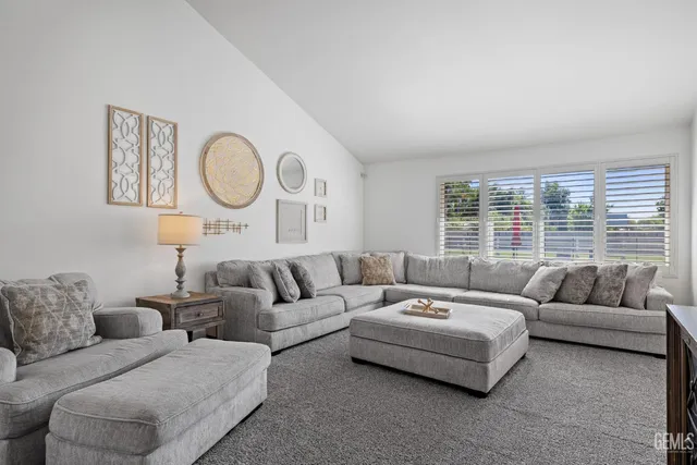 a living room with furniture a flat screen tv and a chandelier