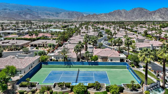 an aerial view of residential houses with outdoor space and trees