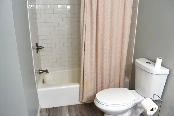 a white toilet sitting next to a bathtub