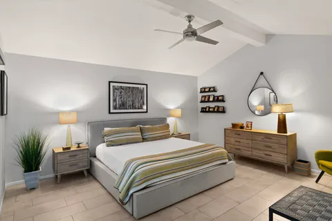 a bedroom with bed and paintings on the wall