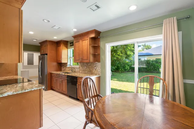 a large kitchen with kitchen island granite countertop a large window and stainless steel appliances