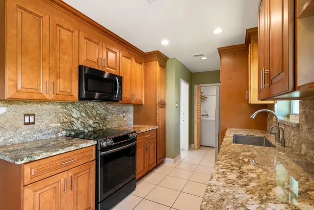 a kitchen with stainless steel appliances granite countertop a sink stove and refrigerator