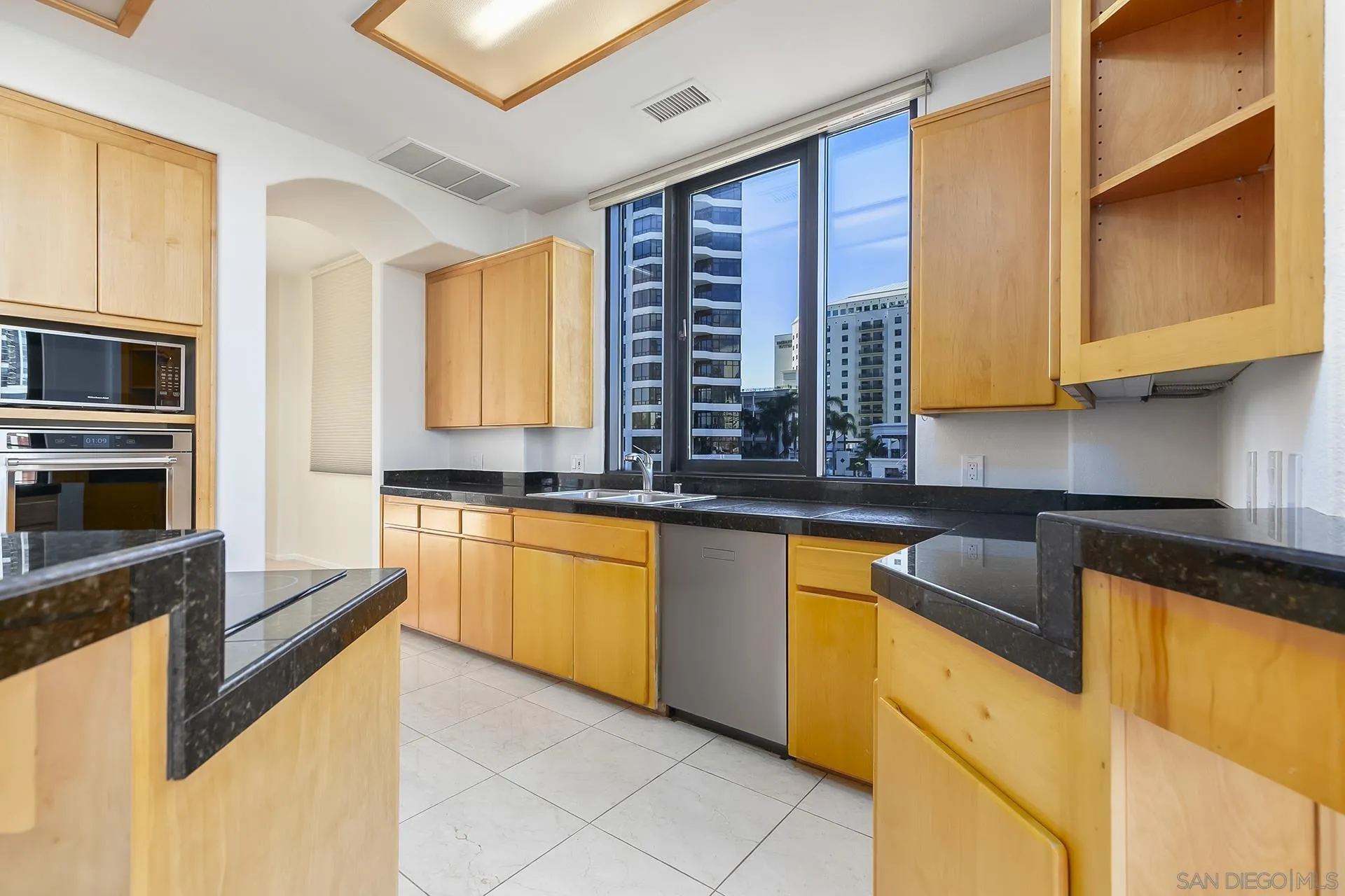 611 West G Street, Unit 321 San Diego, CA 92101 - Photo 10 of 28 a kitchen with stainless steel appliances granite countertop a sink counter space cabinets and a large window