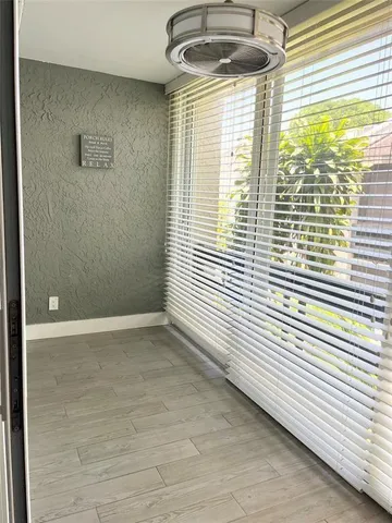 a view of a livingroom with wooden floor and a ceiling fan