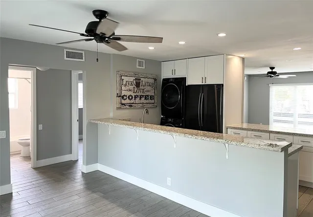 a view of a refrigerator in kitchen and wooden floor