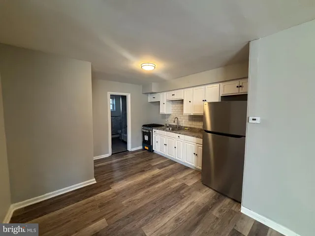 a kitchen with stainless steel appliances a refrigerator and wooden floor