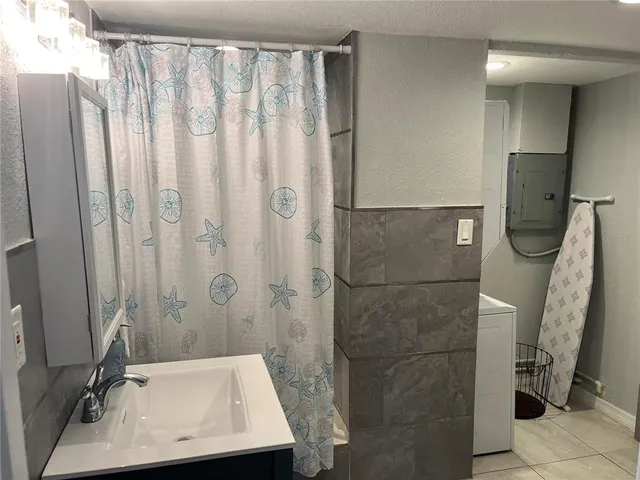 a bathroom with a sink a toilet a window and shower