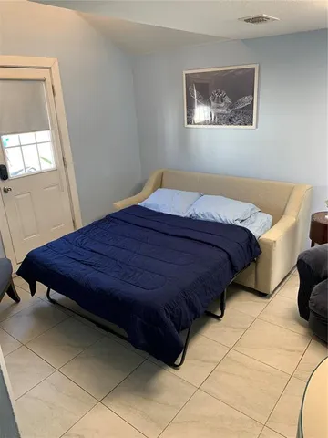 a bed sitting in a bedroom next to a window