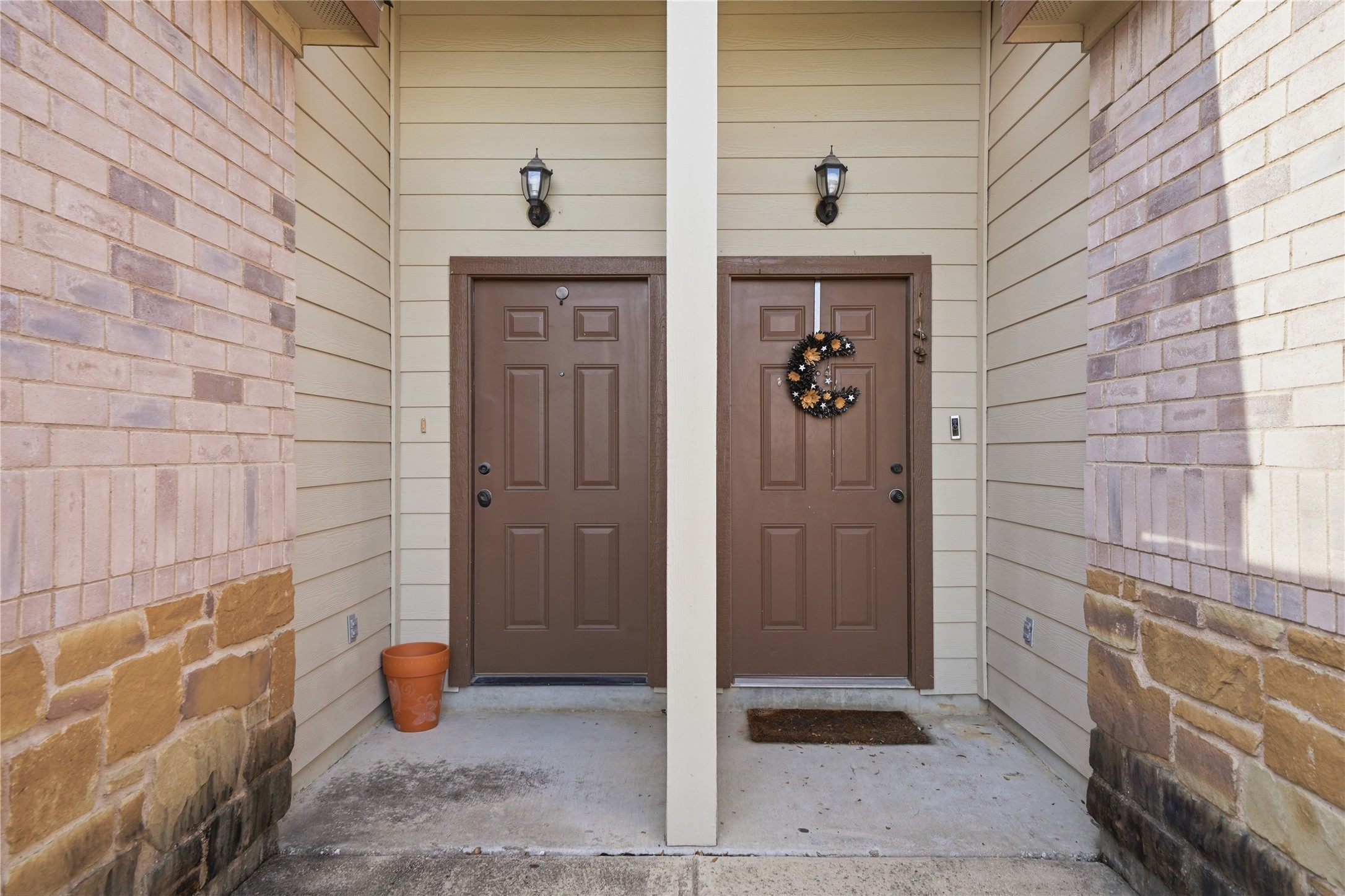 533 Jack Rabbit Lane, Unit A Buda, TX 78610 - Photo 7 of 34 A welcoming entry features sturdy brown doors framed by stone and siding, ready for residents.