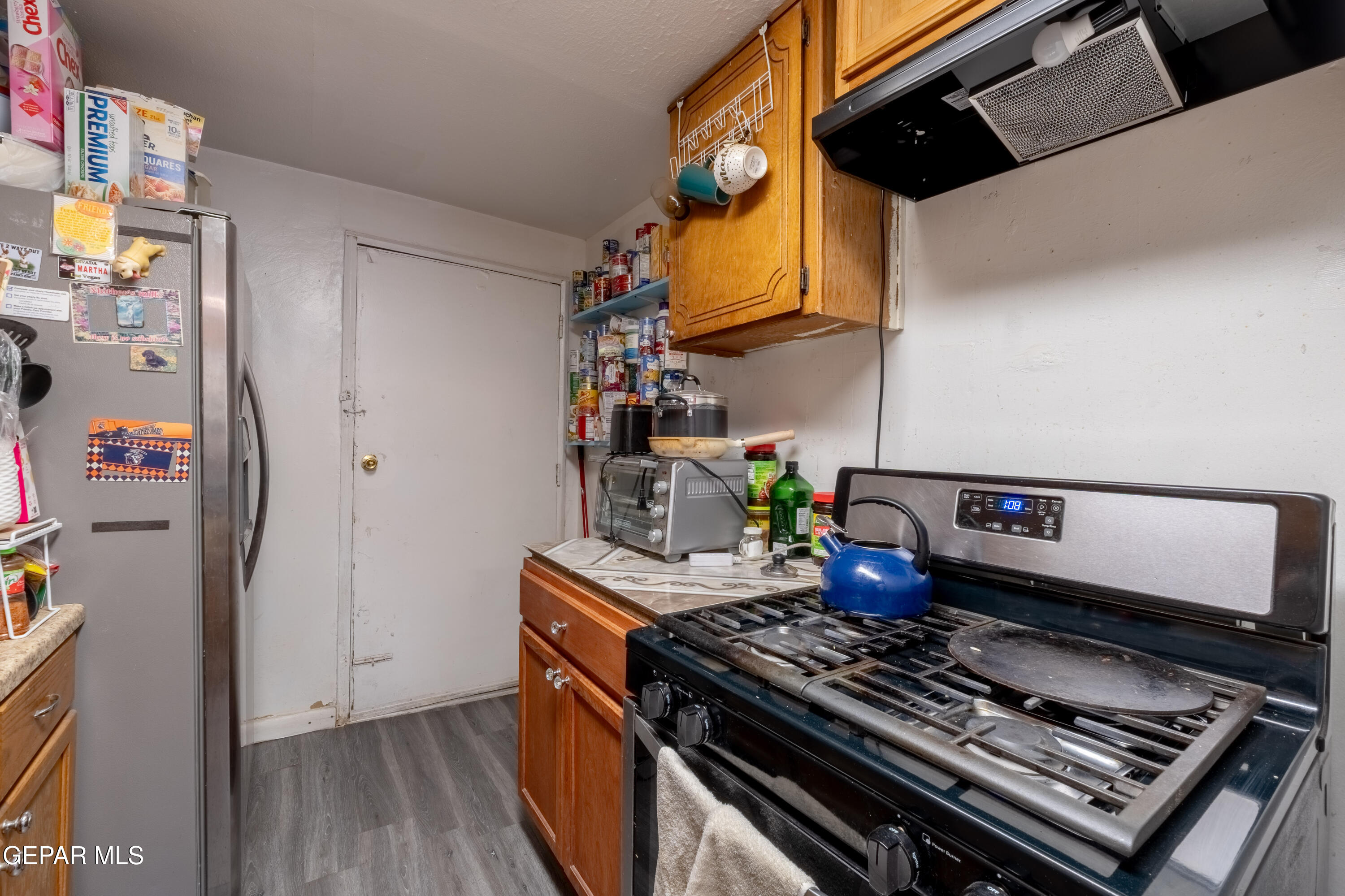 219 Polo Inn Road El Paso, TX 79915 - Photo 11 of 25 a kitchen with stainless steel appliances granite countertop a stove and a refrigerator