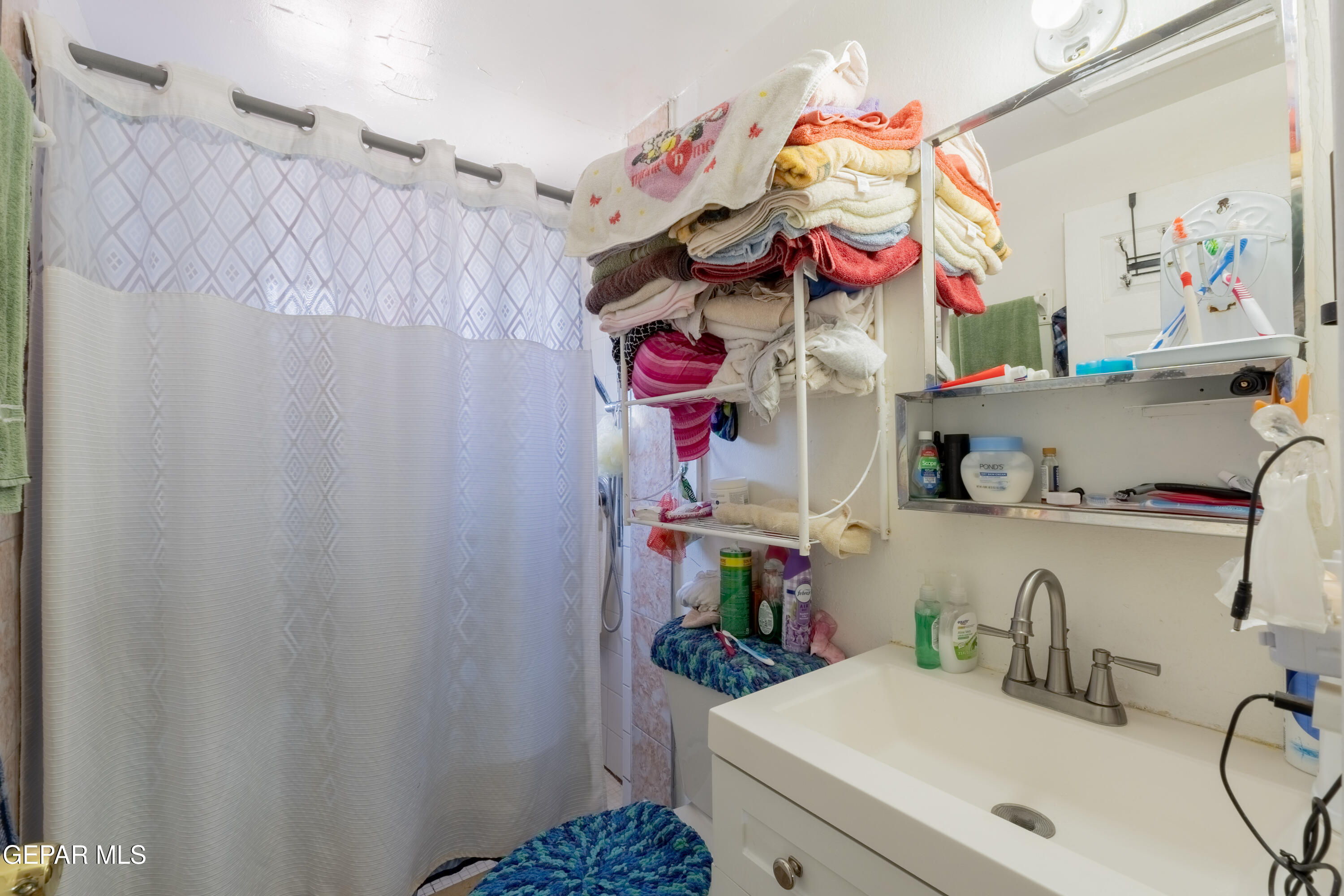 219 Polo Inn Road El Paso, TX 79915 - Photo 14 of 25 a bathroom with a sink mirror and vanity