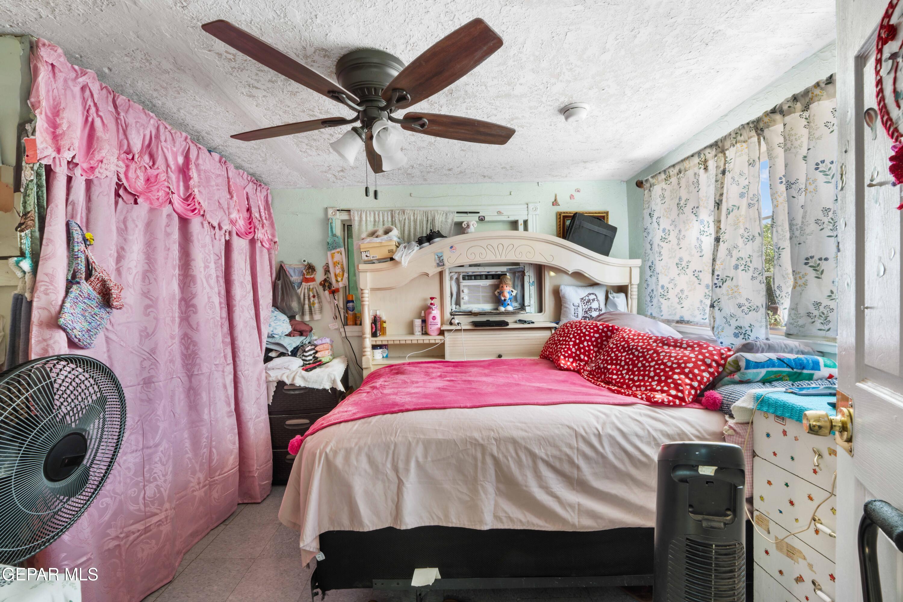 219 Polo Inn Road El Paso, TX 79915 - Photo 15 of 25 a bedroom with a bed and a chandelier