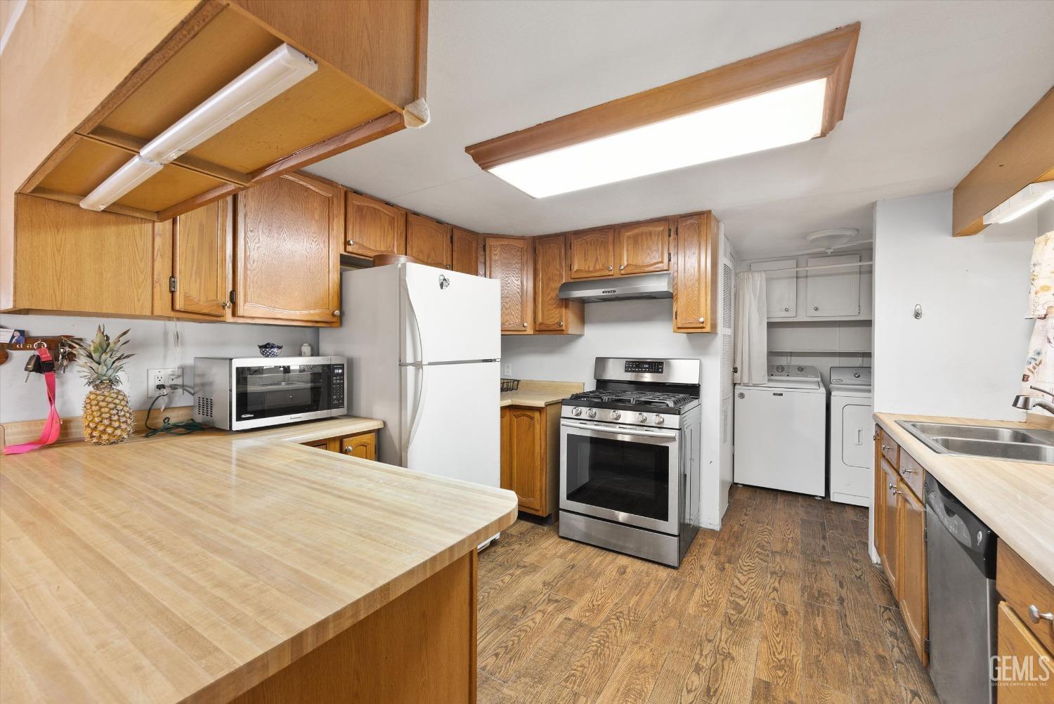 Undisclosed Address Bakersfield, CA 93314 - Photo 13 of 34 a kitchen with stainless steel appliances a stove a refrigerator sink and cabinets