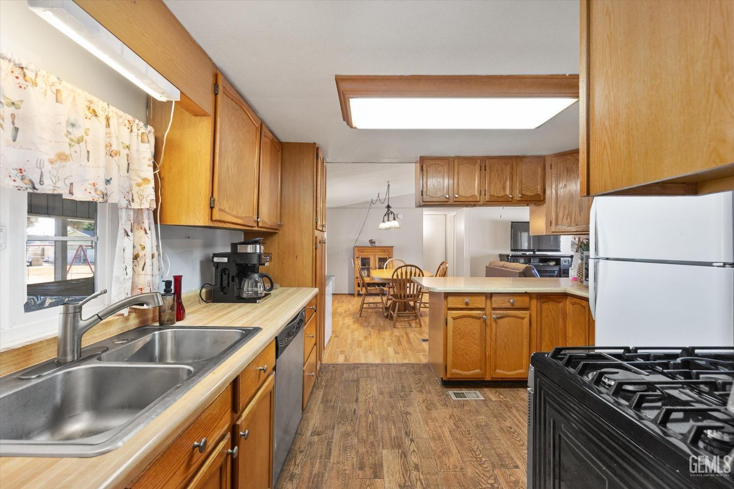 Undisclosed Address Bakersfield, CA 93314 - Photo 14 of 34 a kitchen filled counter top space a sink a stove and a refrigerator