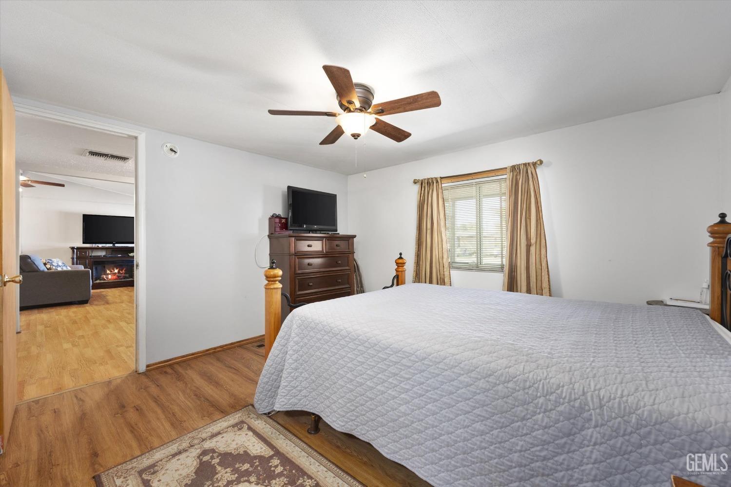 Undisclosed Address Bakersfield, CA 93314 - Photo 16 of 34 a spacious bedroom with a bed and a flat screen tv