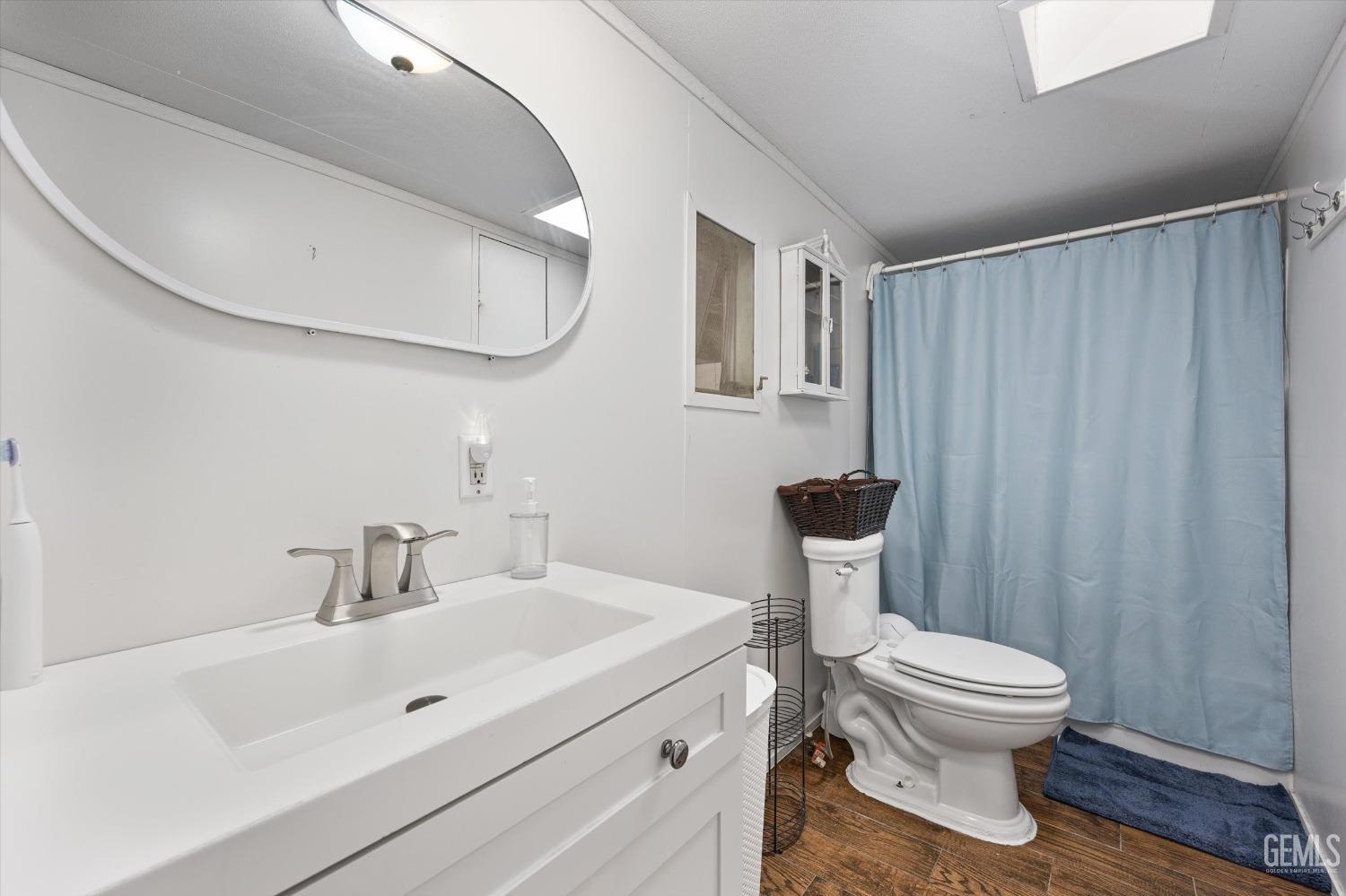 Undisclosed Address Bakersfield, CA 93314 - Photo 17 of 34 a bathroom with a toilet a sink and a mirror