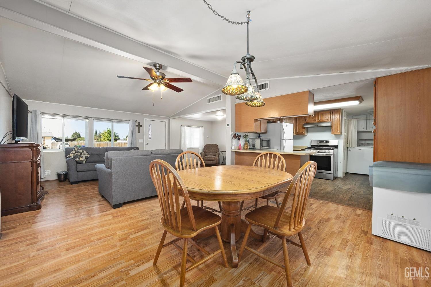 Undisclosed Address Bakersfield, CA 93314 - Photo 10 of 34 a dining room with stainless steel appliances kitchen island granite countertop a table chairs and a refrigerator