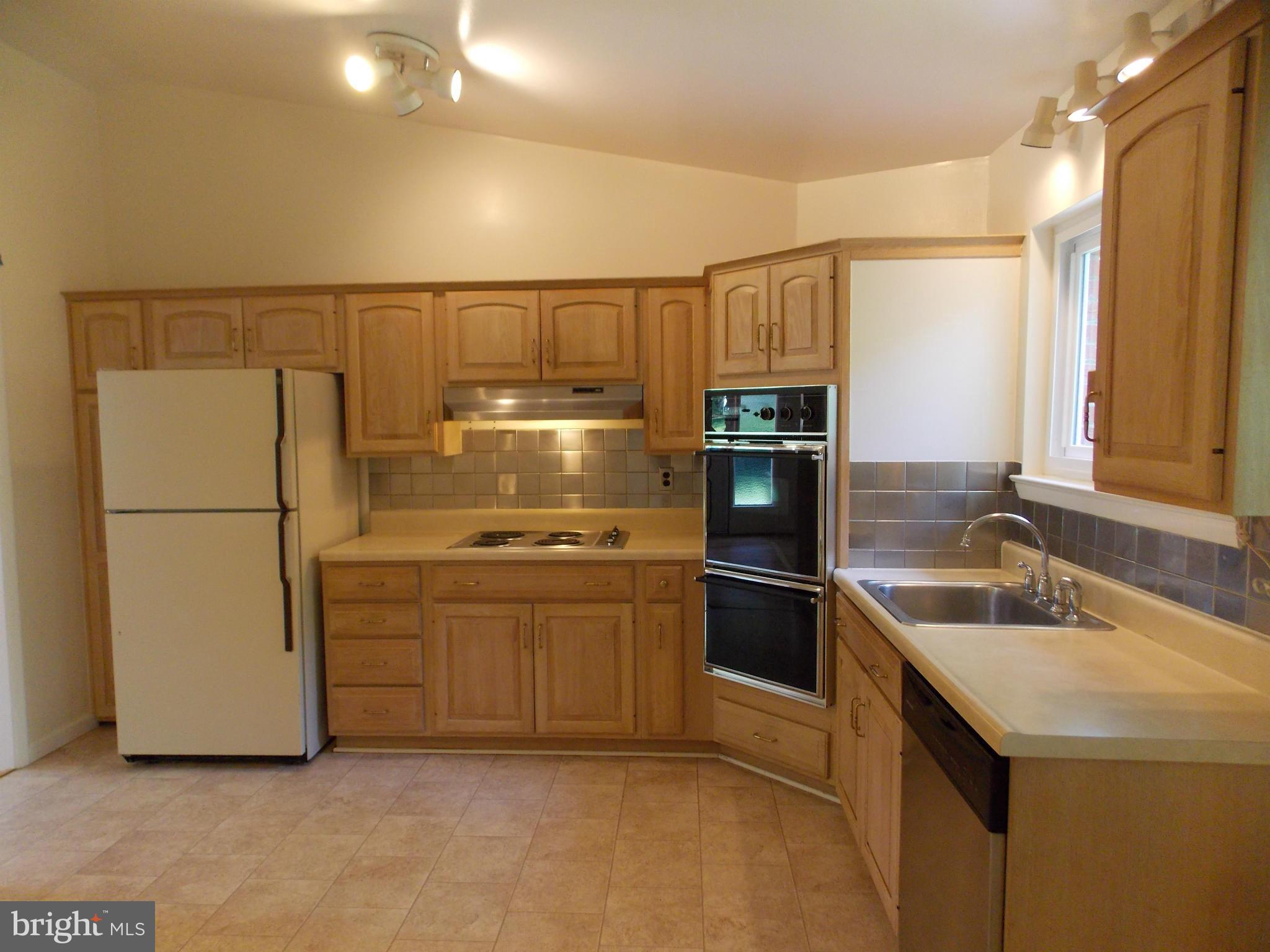 1615 Ladd Street Silver Spring, MD 20902 - Photo 3 of 30 a kitchen with stainless steel appliances granite countertop a refrigerator a sink and white cabinets