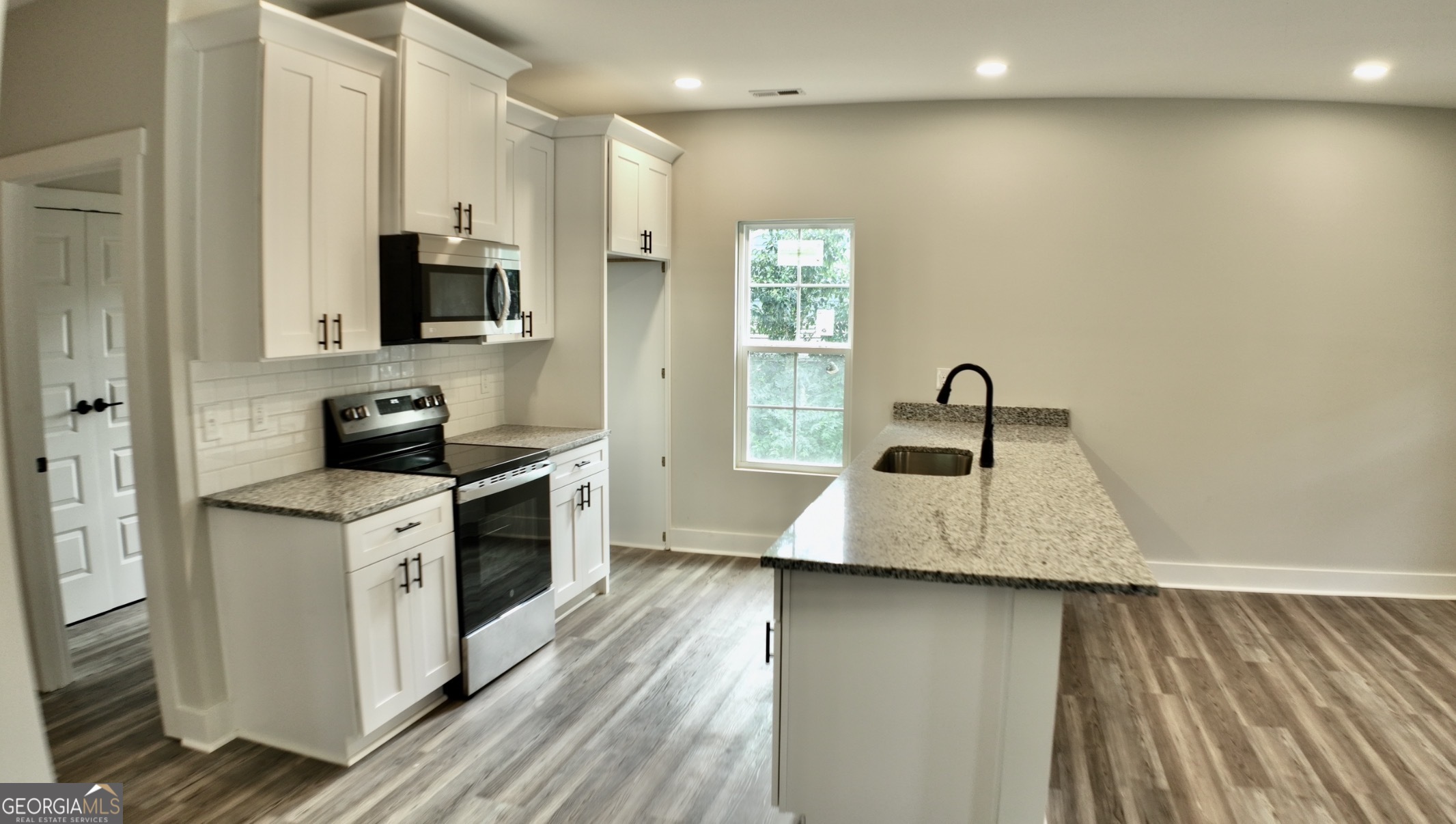 769 Horsley Mill Road Carrollton, GA 30116 - Photo 3 of 7 a kitchen with stainless steel appliances granite countertop a sink a stove top oven a counter space and cabinets