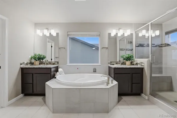 a bathroom with a tub sink and mirror