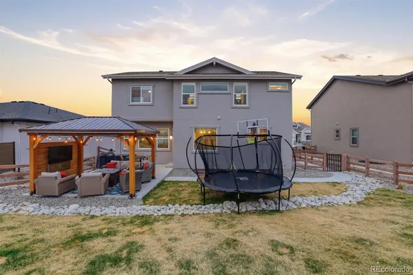 a view of a house with a backyard and furniture