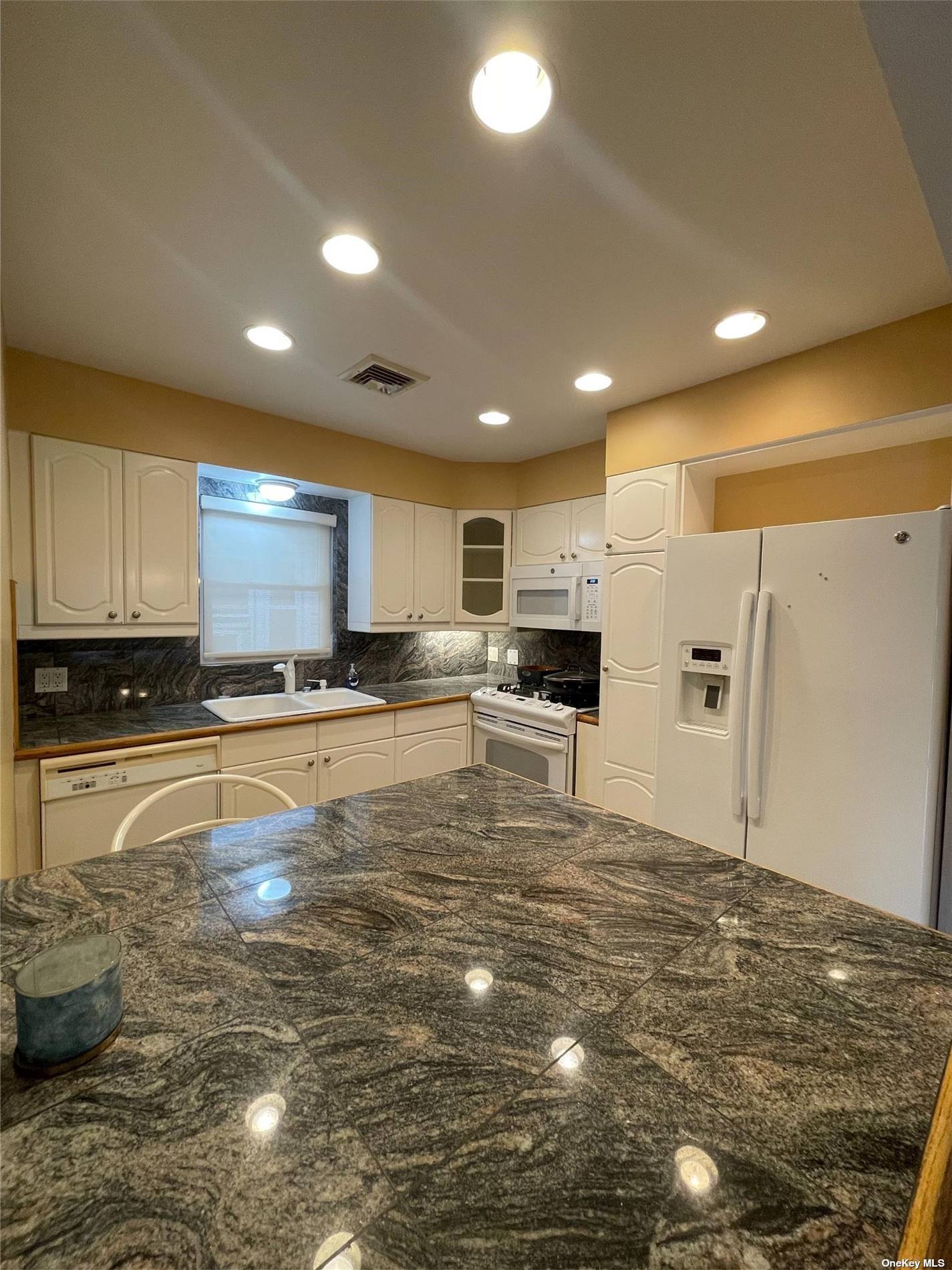 a large kitchen with stainless steel appliances lots of counter space and a refrigerator