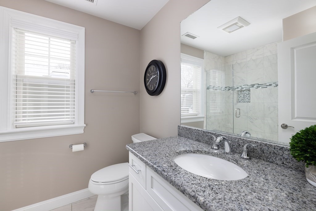 55 Kendall Road Lexington, MA 02421 - Photo 19 of 32 a bathroom with a granite countertop toilet a sink and a mirror