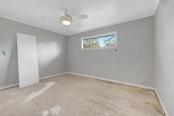 an empty room with a ceiling fan and window