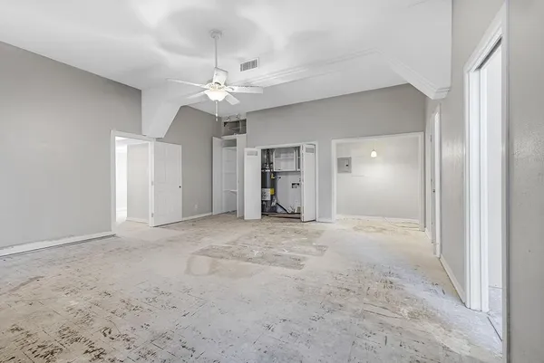 an empty room with fan and entrance