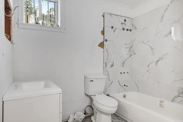 a white toilet sitting next to a bath tub shower