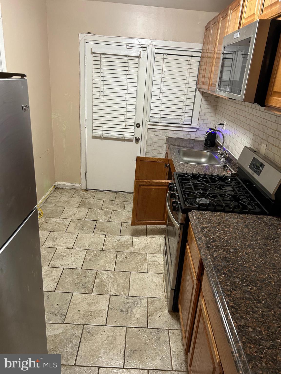 3203 Kenyon Avenue Baltimore, MD 21213 - Photo 8 of 28 a kitchen with a stove a refrigerator and a sink