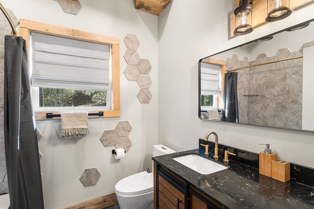 126 Hummingbird Way Copperhill, TN 37317 - Photo 24 of 47 a bathroom with a granite countertop sink mirror vanity and toilet