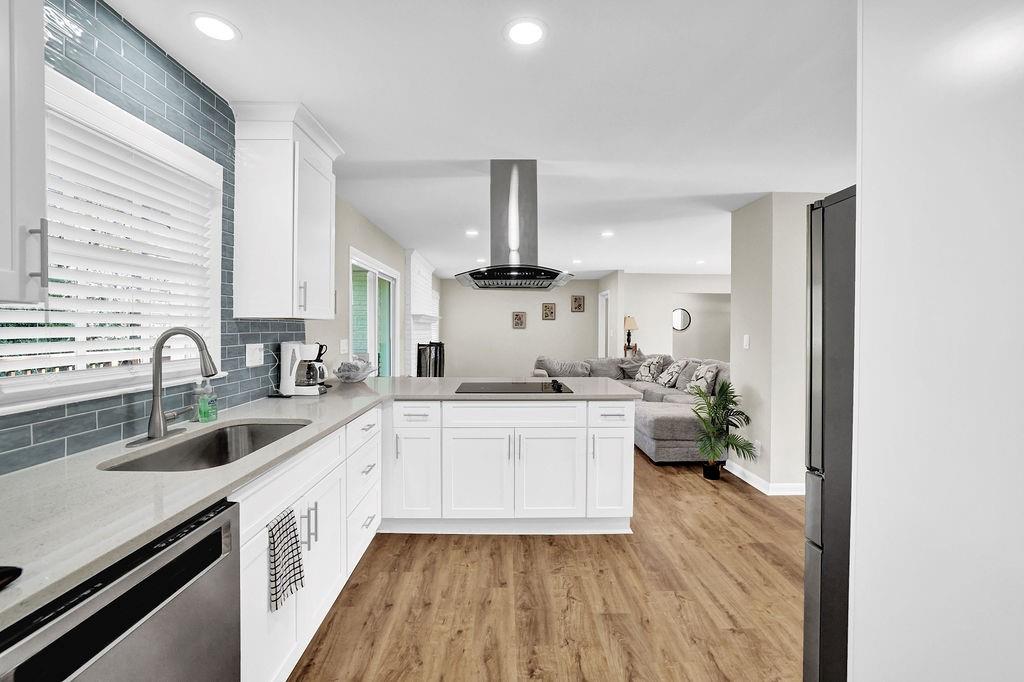 4420 Lavista Road Tucker, GA 30084 - Photo 16 of 36 a kitchen with a sink dishwasher a stove and white cabinets with wooden floor