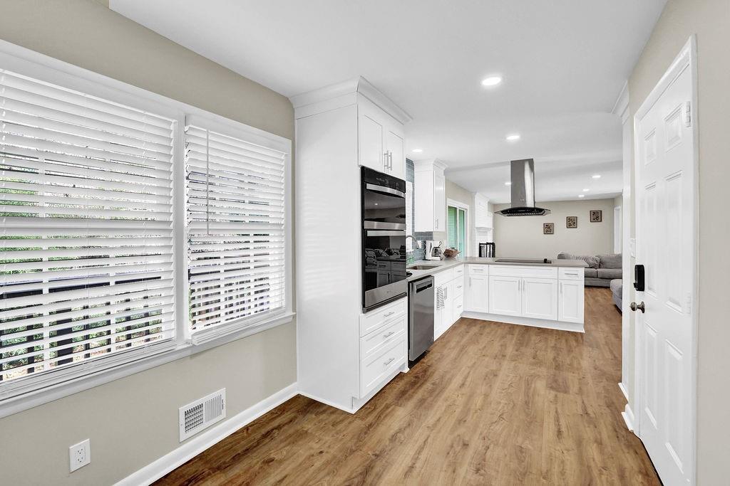 4420 Lavista Road Tucker, GA 30084 - Photo 17 of 36 a large kitchen with kitchen island wooden floors white cabinets and stainless steel appliances