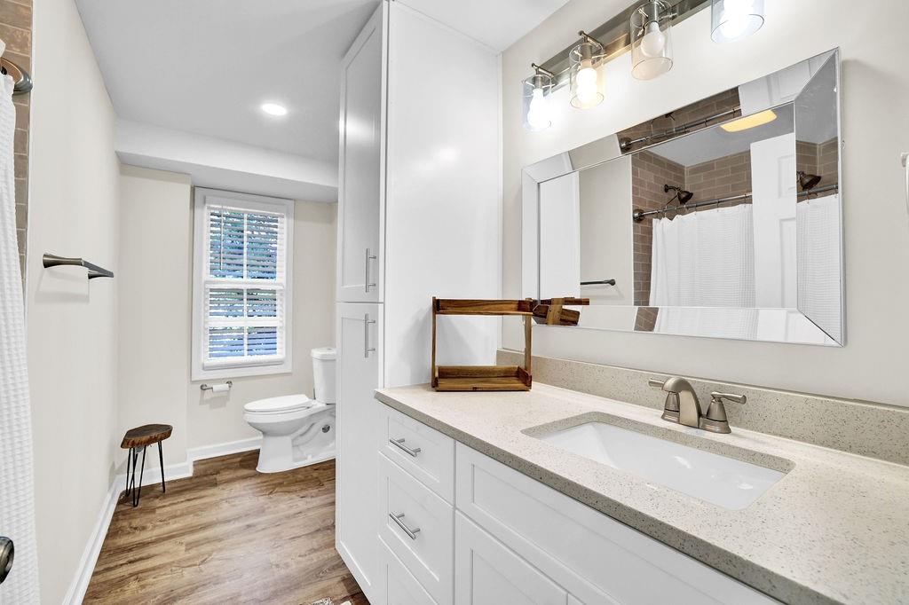 4420 Lavista Road Tucker, GA 30084 - Photo 31 of 36 a bathroom with a granite countertop sink a toilet and a large mirror