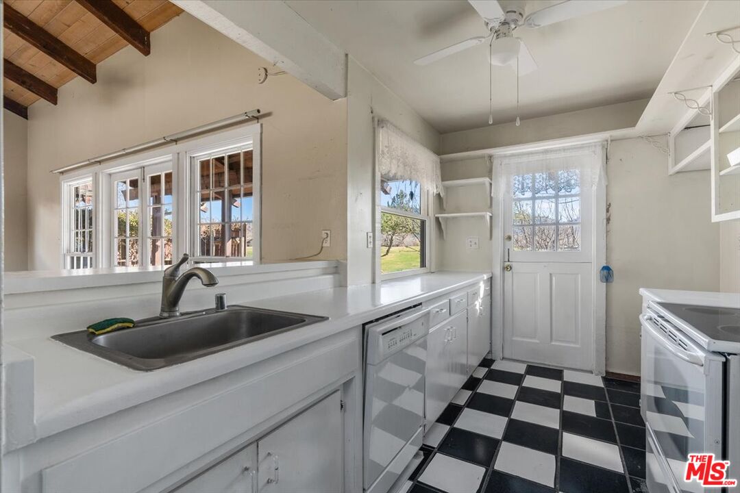 57 Meadow Lakes Drive Tehachapi, CA 93561 - Photo 11 of 26 a kitchen with a sink a refrigerator and cabinets